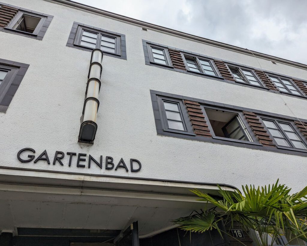 Die Fassade des Gartenbad Fechenheim mit altem Schriftzug und historischer Beleuchtung