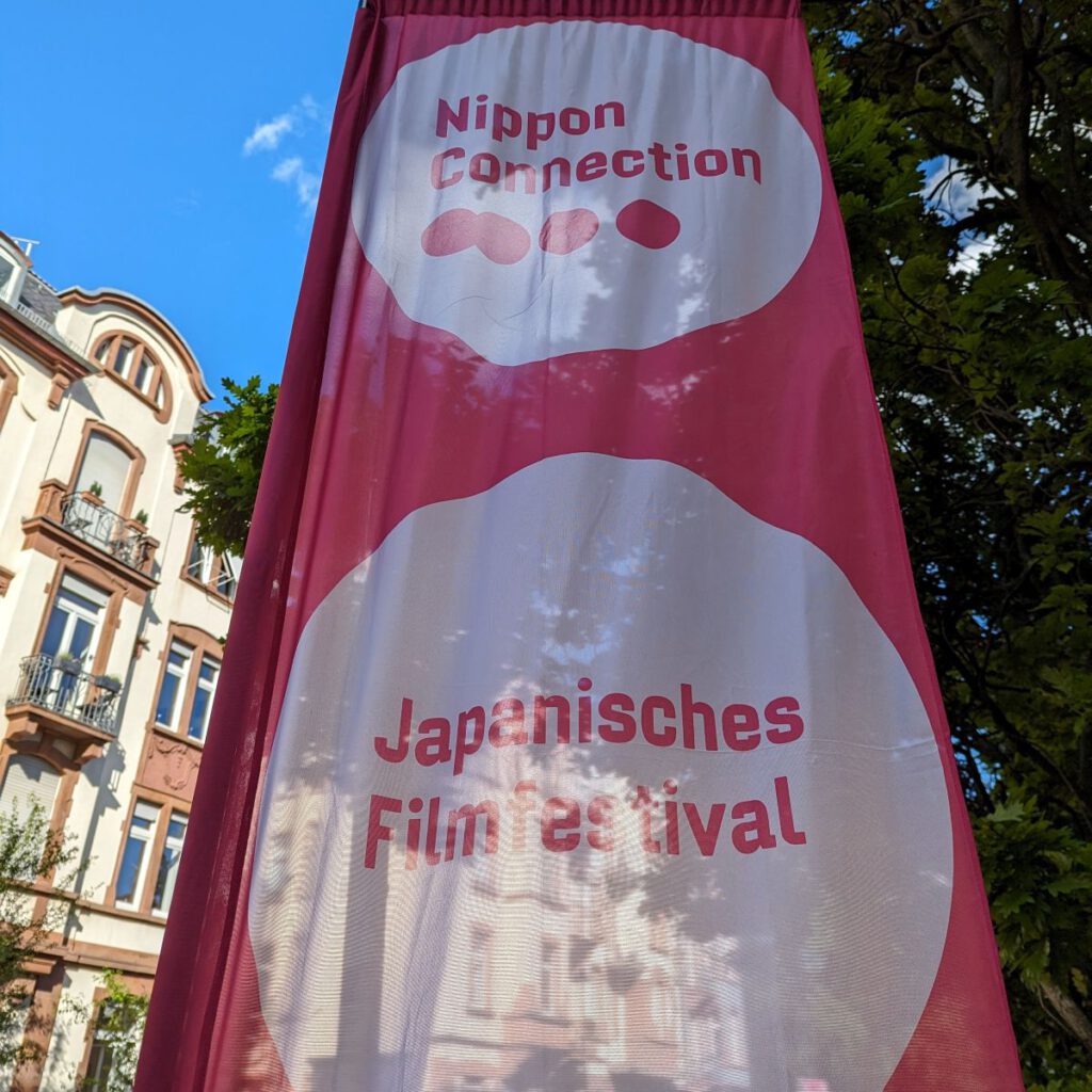 Pinkfarbene "Nippon Connection"-Flagge vor dem Mouson-Turm