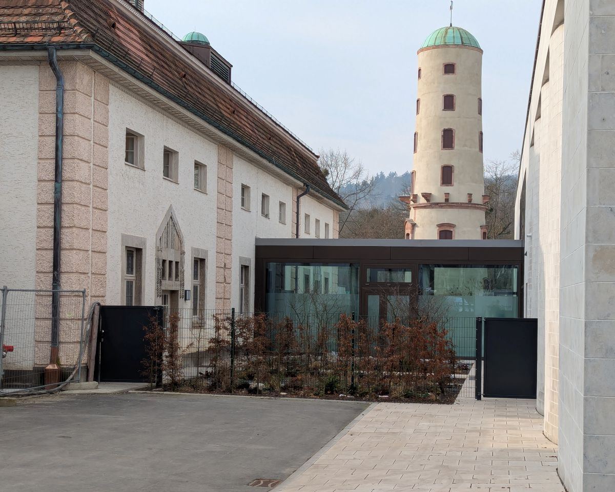 Verglaste Verbindung zwischen der neugebauten Therme und dem alten Badehaus, dahinter der Waitzsche Turm