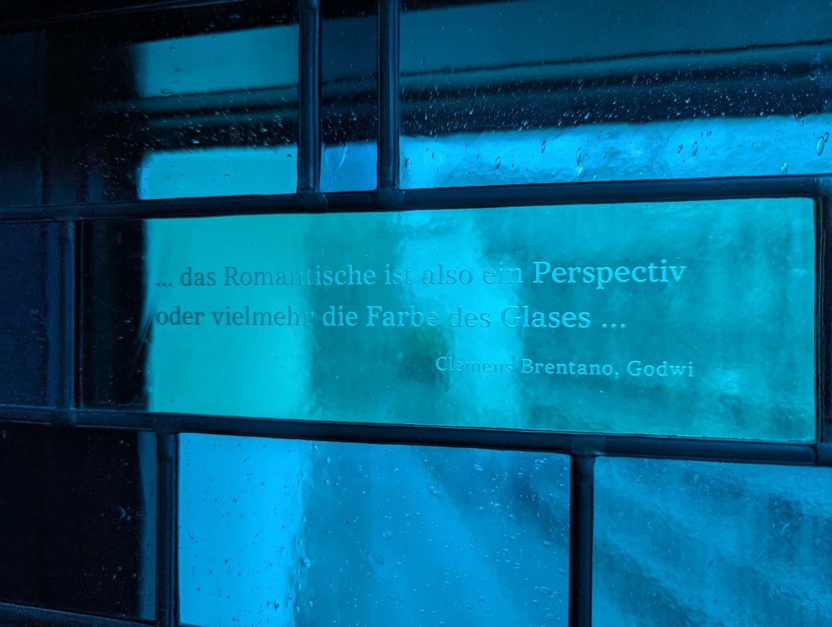 Zitat in blauem Glas: "... das Romantische ist also ein Perspectiv oder vielmehr die Farbe des Glases ..." Clemens Brentano
