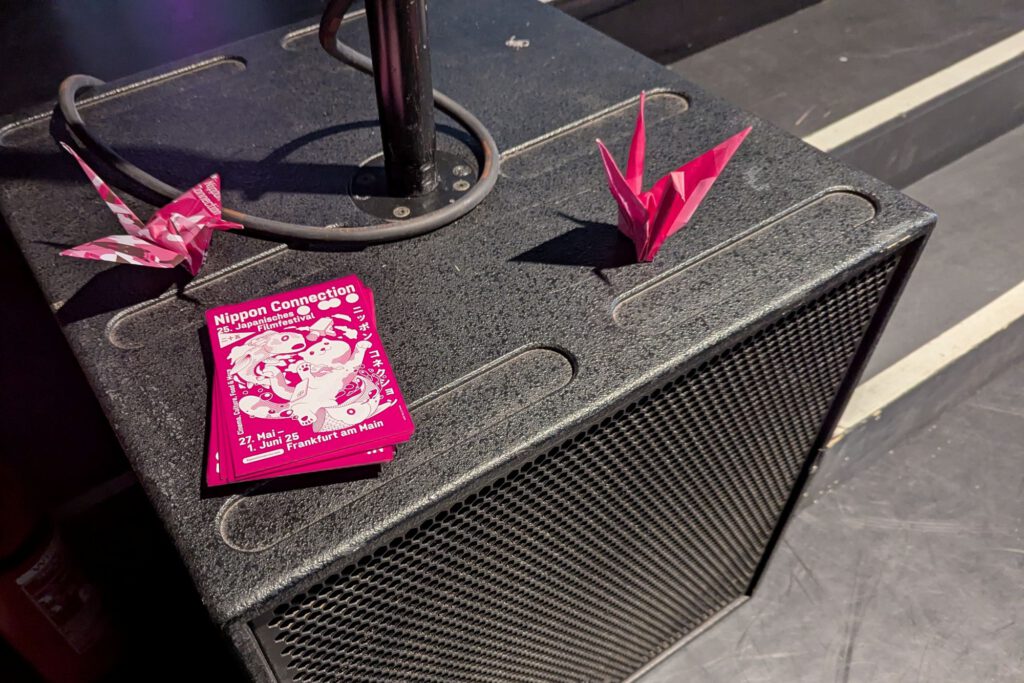 Veranstaltungslautsprecher dekoriert mit rosa Origami-Kranichen.