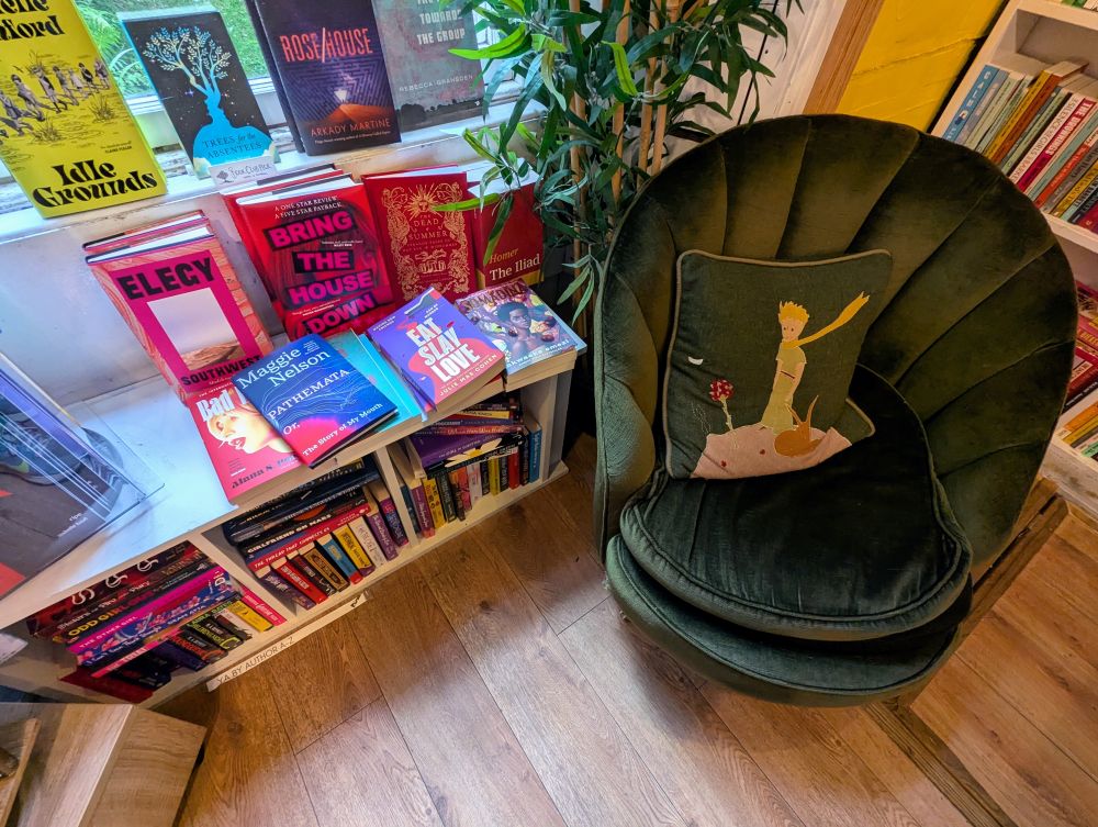 Gemütliche Leseecke im Lighthouse Bookshop, den Sessel ziert ein Kissen mit dem kleinen Prinzen.