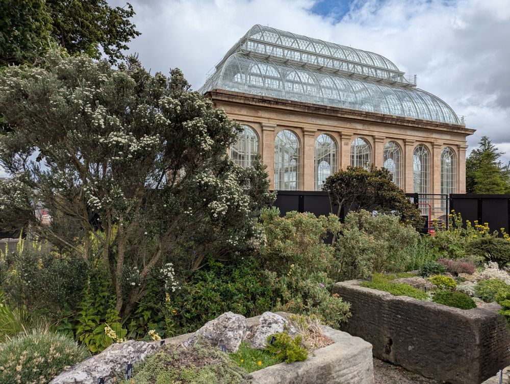 Das alte Gewächshaus des Royal Botanical Garden, davor Tröge mit Steinpflanzen.