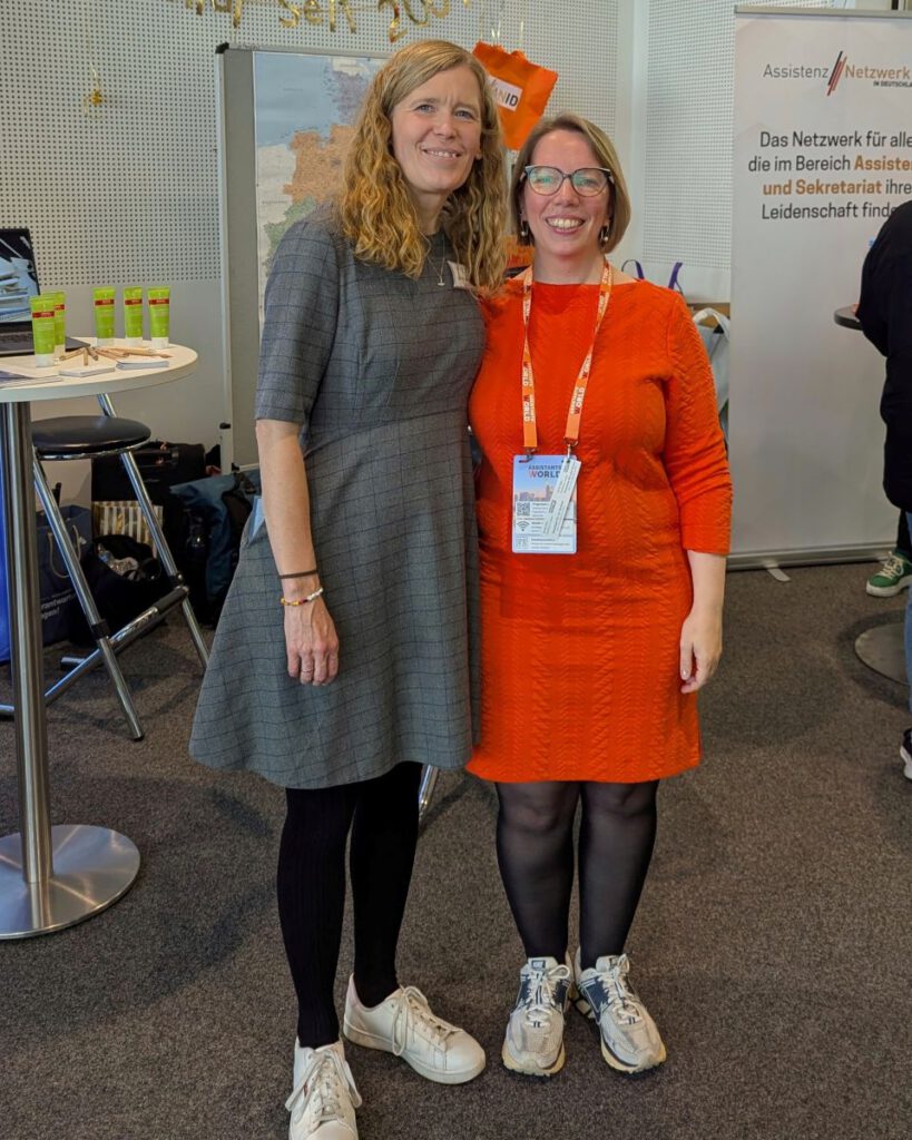 Judith Ahrhold und Astrid Schewe vor dem Stand des ANiD auf der Assistants World.