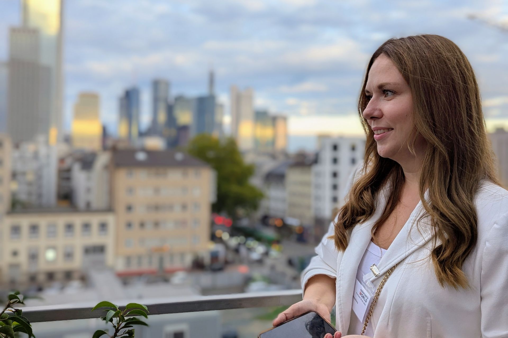 Katja Jeroschina steht nicht gern im Mittelpunkt, hier blickt sie gelassen auf die Frankfurter Skyline, das Smartphone in der Hand.
