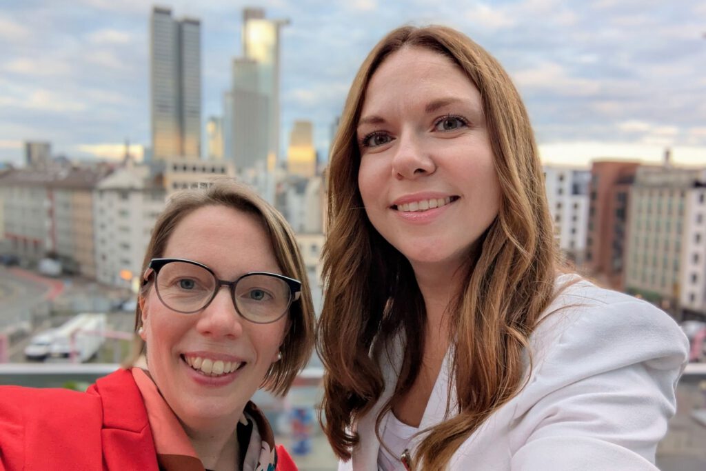Astrid Schewe und Katja Jeroschina beim gemeinsamen Selfie auf der Dachterasse für der Frankfurter Skyline im Abendlicht.