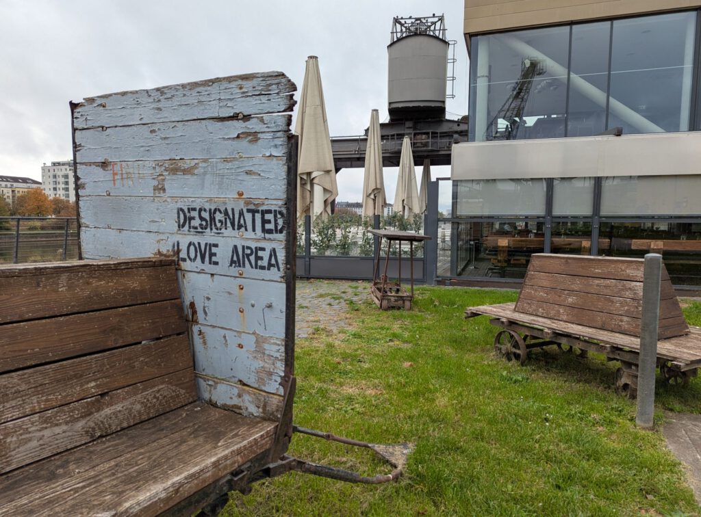 Sitzbänke aus alten Holzplanken und sehr alten Rädern in Industrial-Style. Auf einer Bank steht "Designated Love Area".